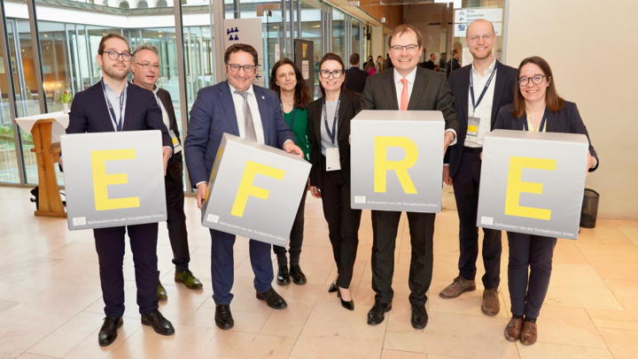 Bayerns Wirtschaftsstaatssekretär Tobias Gotthardt mit Vertretern der EFRE-Verwaltungsbehörde mit den EFRE-Sitzwürfeln